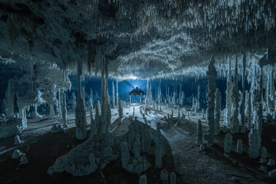 A diver using a rebreather glides through a cave in the Yucatán Peninsula