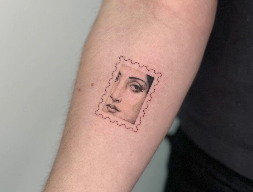a photograph of a postage stamp-shaped tattoo on a forearm, containing a compositional detail of three-quarters of a woman's face