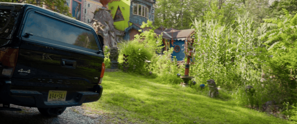 a gif of a large, whimsical house in the woods that an artist built from scratch