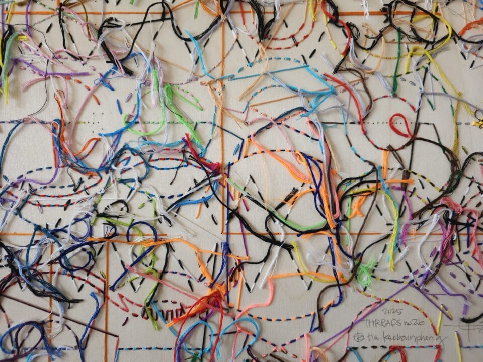 the reverse of an artwork made from numerous colors of thread woven through a panel