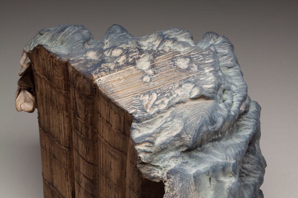 a detail of the top of a sculpture made from a set of large books, covers removed to reveal the stitched binding, which has been water-blasted to soften and manipulate the pages into a form resembling a large mountain