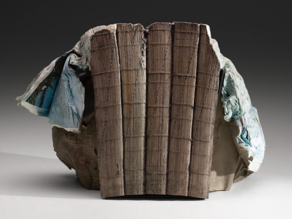 a sculpture made from a set of large books, covers removed to reveal the stitched binding, which has been water-blasted to soften and manipulate the pages