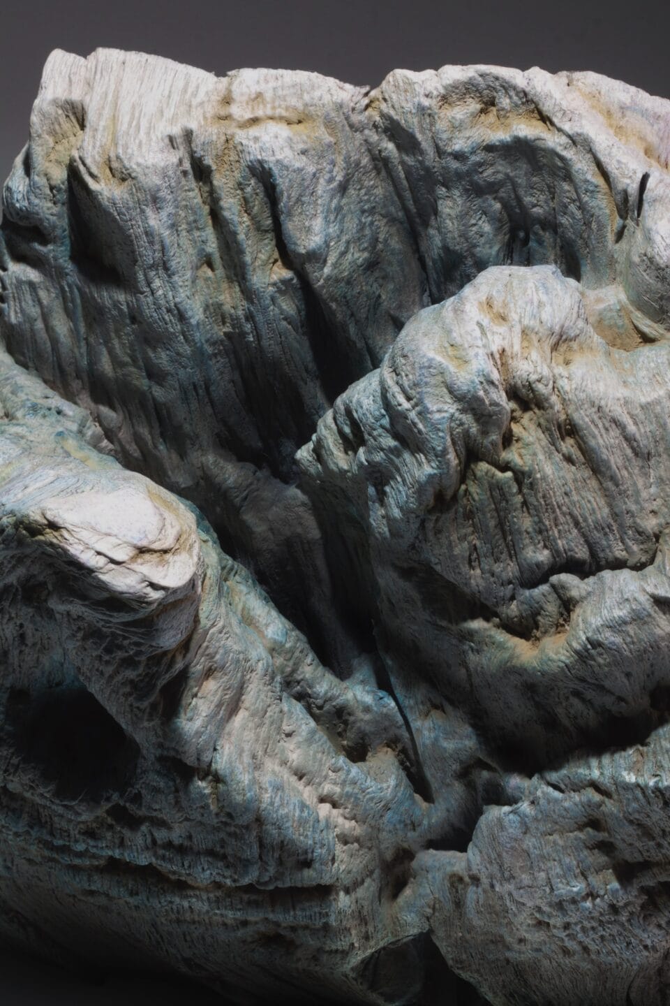 a detail of the craggy texture of a sculpture made from a set of large books, covers removed to reveal the stitched binding, which has been water-blasted to soften and manipulate the pages into a form resembling a large mountain