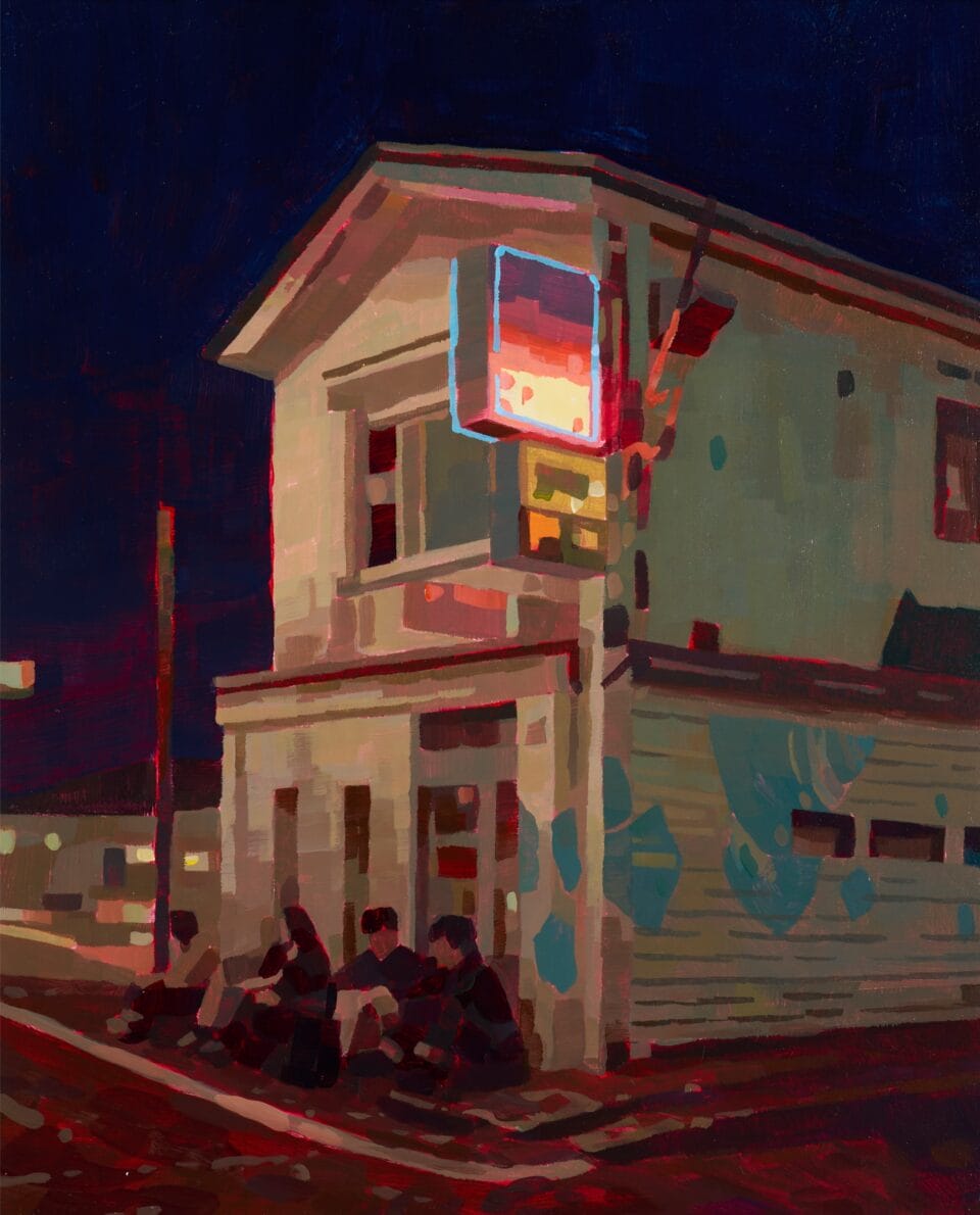 a group of people sit on the sidewalk outside a bar lit by a glowing sign