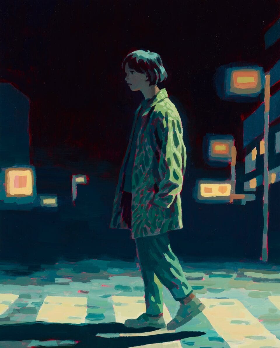 a person walks across a crosswalk illuminated by a streetlight
