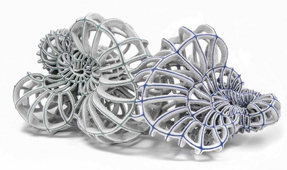 an abstract ceramic sculpture with blue porcelain and white flocked-like surfaces with numerous spokes and irregular concentric circles
