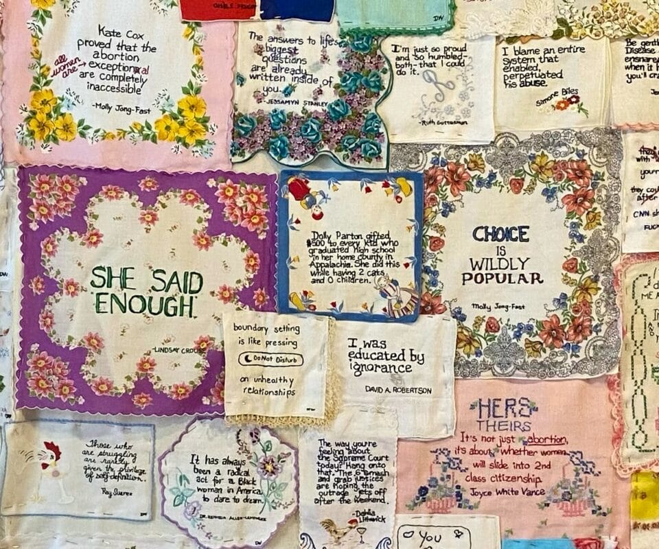 detail of a tapestry of embroidered sayings dealing with womens rights and bodily autonomy