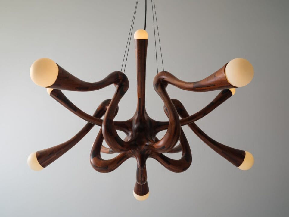 a wooden light fixture made of small pieces of wood stacked together
