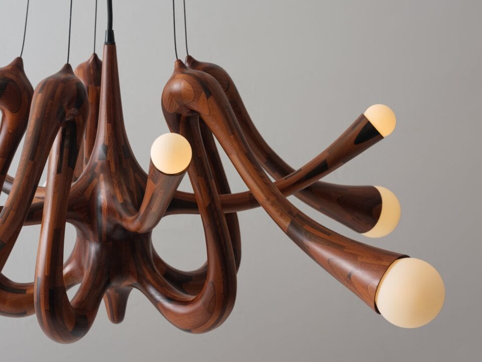 a wooden light fixture made of small pieces of wood stacked together