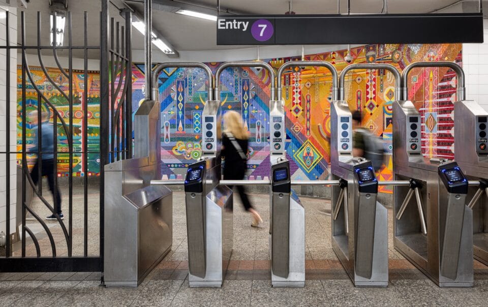 a vibrant geometric mural behind turnstiles