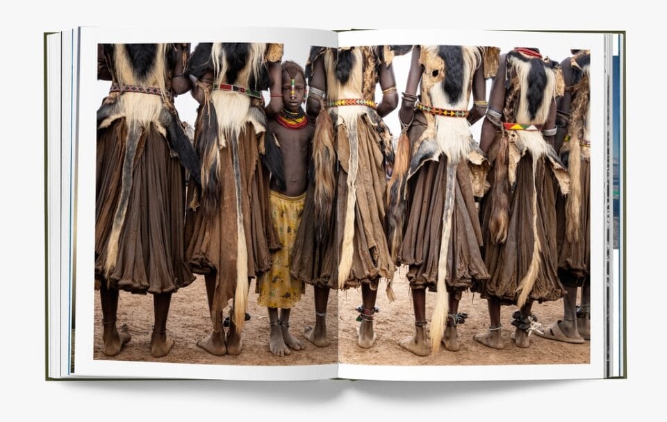 a spread from the book 'HOPE' showing a line of women with brown skirts on, with a child peeking through the skirts back at the viewer