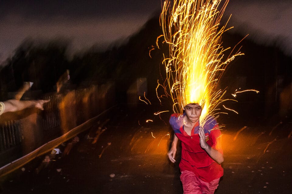 a kid running with sparklers appearing to stream from his head
