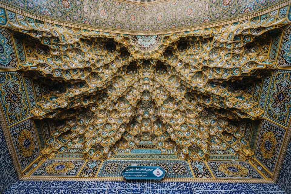 a photograph of an extremely elaborate Muslim shrine in Iran with lots of mosaicked facets and patterns