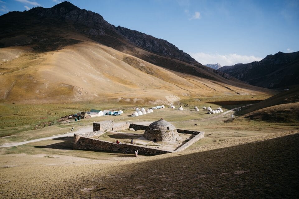 historic stone ruins with a dome and wall enclosure amid mountains
