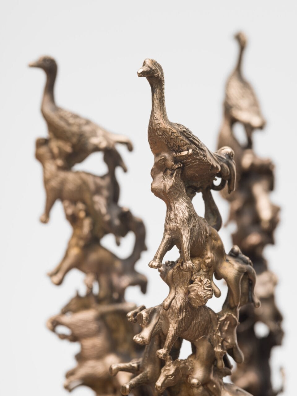 a detail of a sculpture of a gold-coated bronze crown composed of tiny birds and other animals