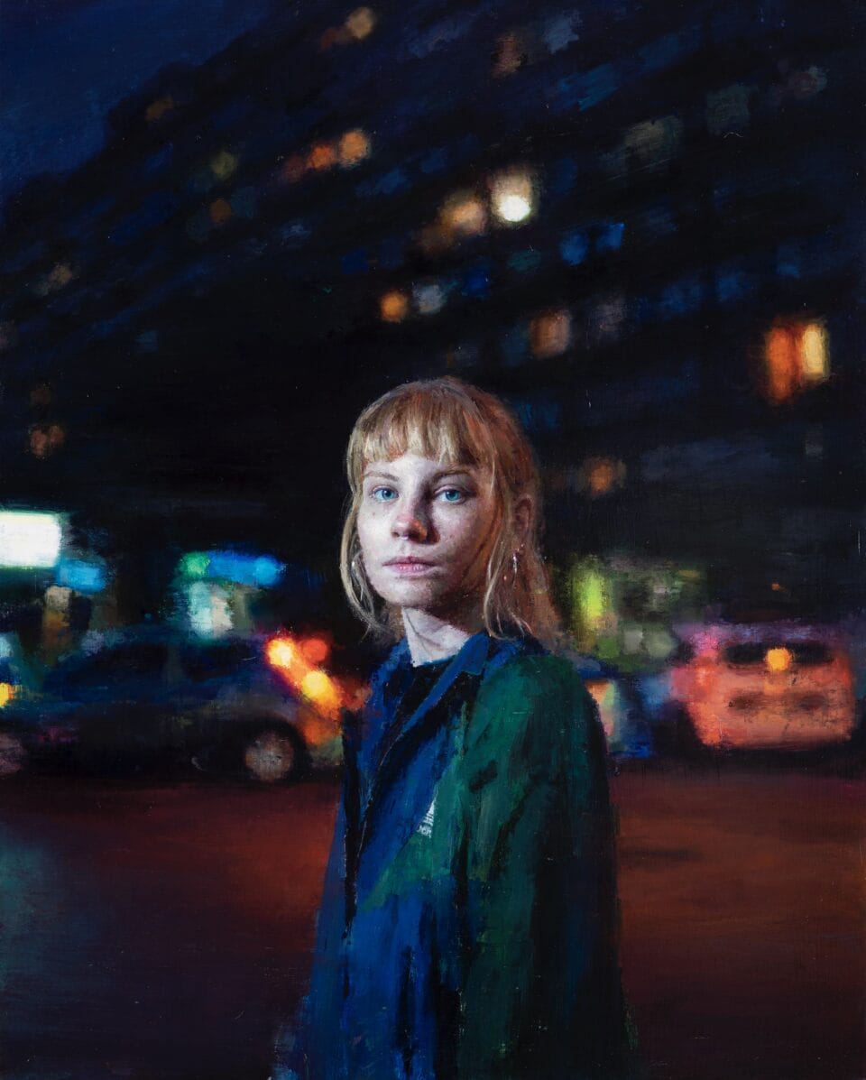 an oil portrait of a young woman with blonde hair pulled back and wearing a blue jacket, pictured at night with her face illuminated and buildings in the background