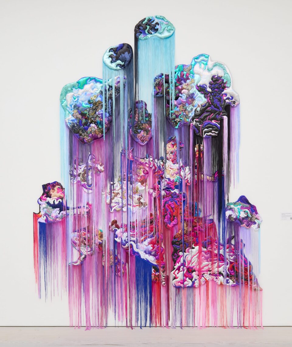 a monumental, abstract wall installation that appears to be cascading in purple, teal, and pink hues