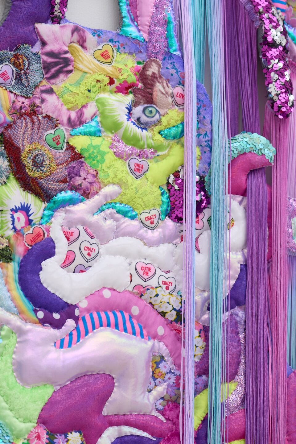 a detail of a monumental, abstract wall installation that appears to be cascading or bleeding a range of neon colors, as if the medium has been thrown at the wall and it is dripping down to the floor