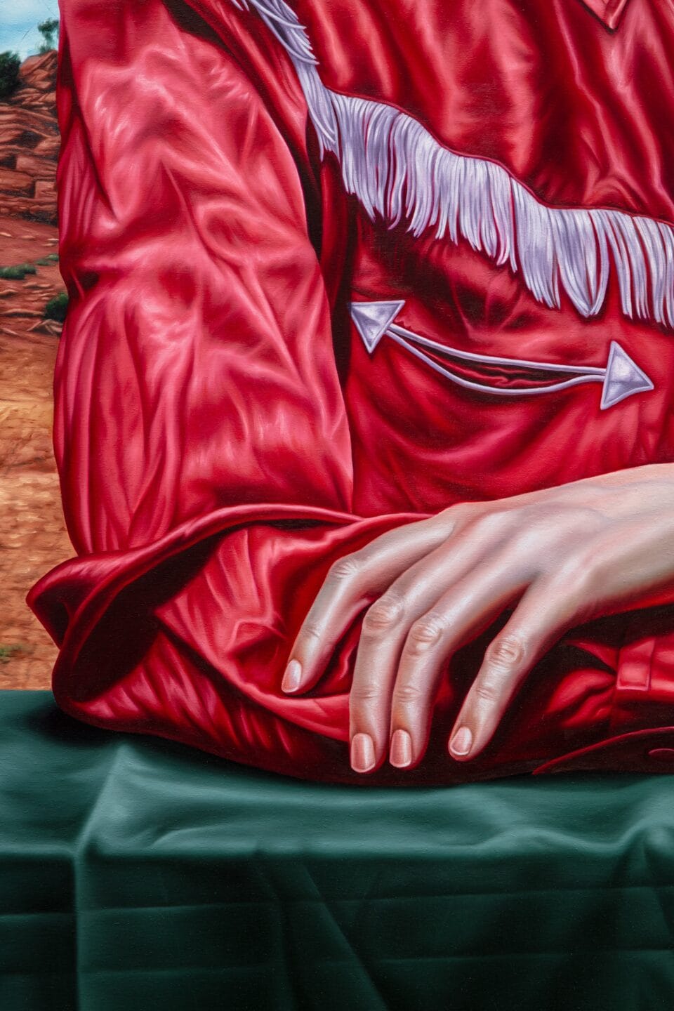 a detail of an oil painting showing a woman's hand and the fabric details of a red Western shirt
