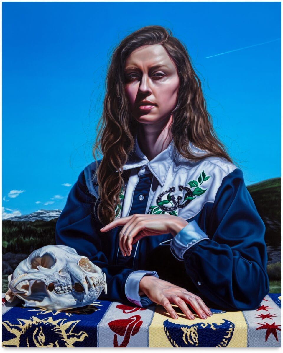 a portrait of a brown-haired woman seated at a table next to an animal skull against a blue sky